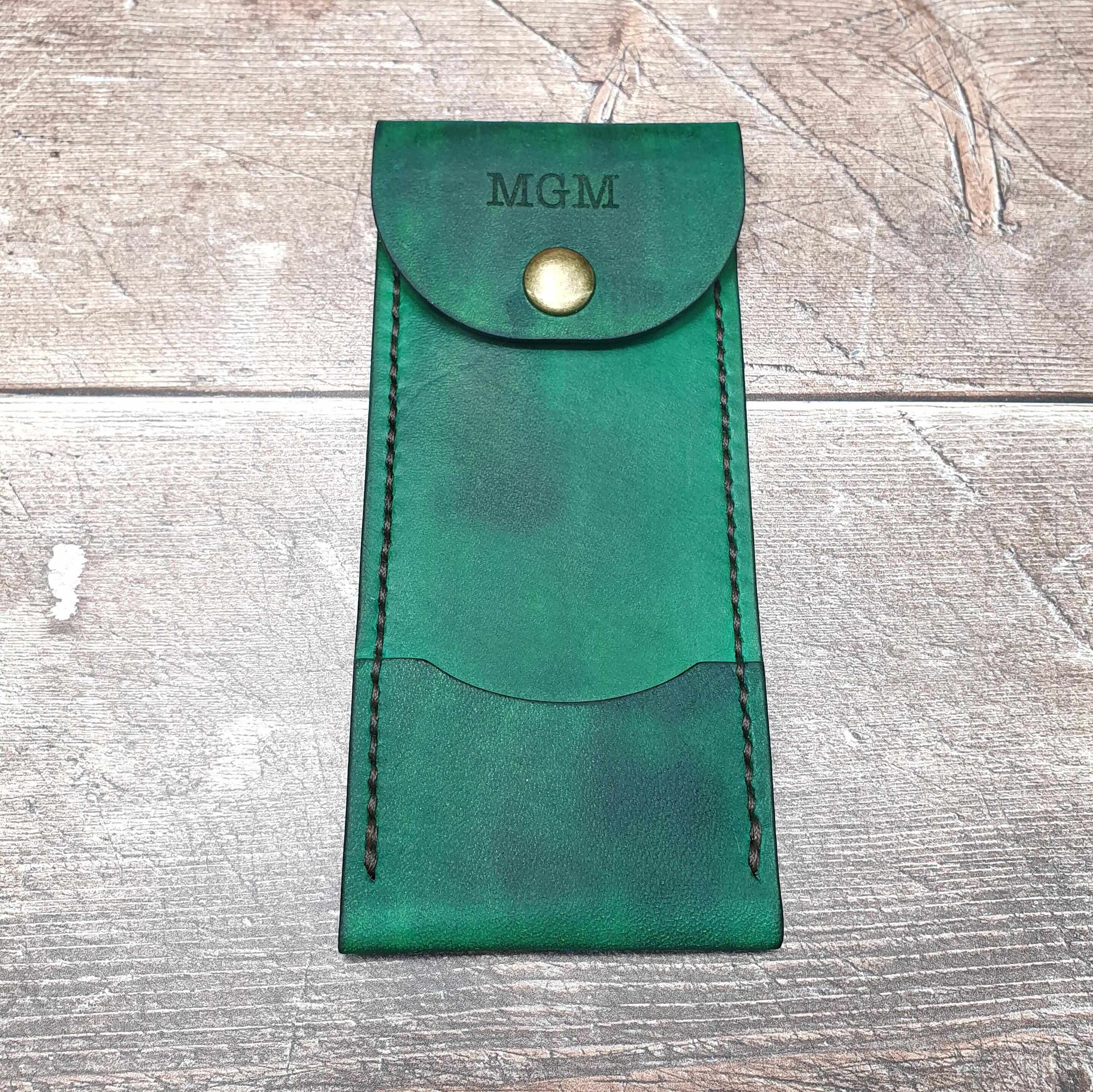 Personalized leather darts case in green with snap popper fastening and custom initials on top.